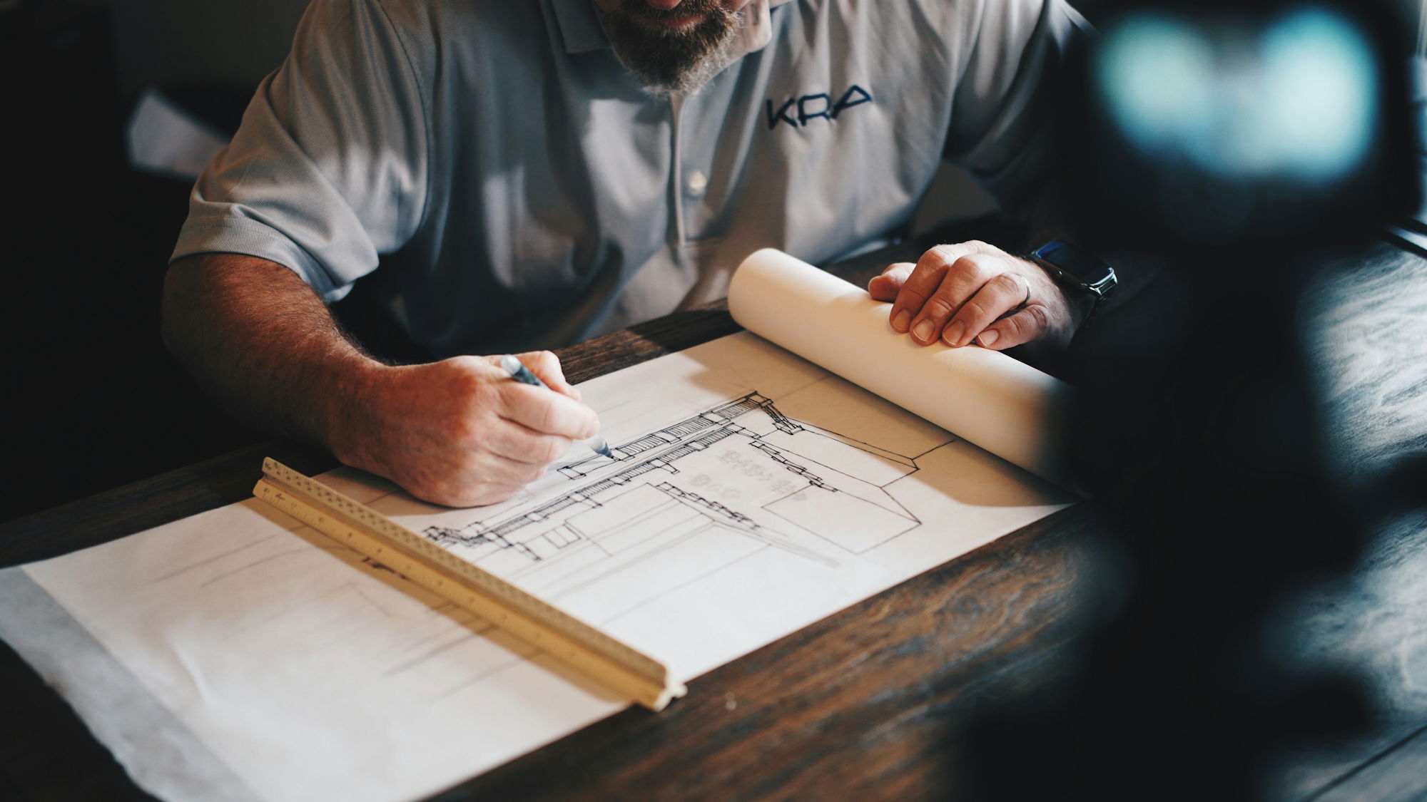 an-architect-working-on-a-draft-with-a-pencil-and-ruler.jpg An architect working on a draft with a pencil and ruler